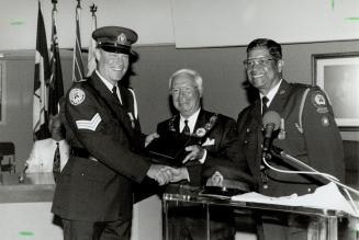 Smiles all around. Inspector Frank Fernandes (right) and Scarborough Mayor Frank Faubert present a special appreciation plaque to Metro police Sergean(...)