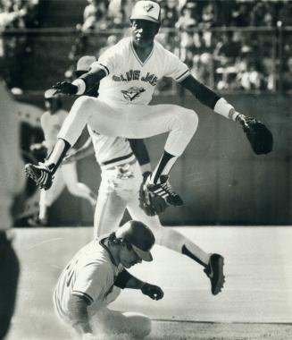His skills honed in his native Dominican Republic, Toronto Blue Jay shortstop Tony Fernandez leaps high to get off a throw to first base. He hails fro(...)