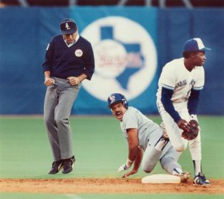 Ouch! Something was afoot. Tony Fernandez was sneaking toward second. It's a pickoff play. Texas runner Fred Manrique has to scamper back. He's safe, (...)
