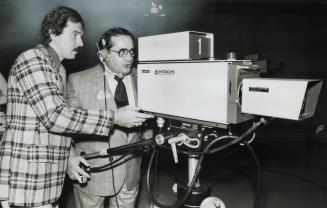 Mayor Dennis Flynn checks out television camera with program director John Haynes (left) after officially opening expanded studio of Maclean-Hunter Ca(...)