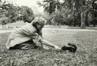 Ex-environment minister Susan Fish feeds squirrel at Queen's Park while