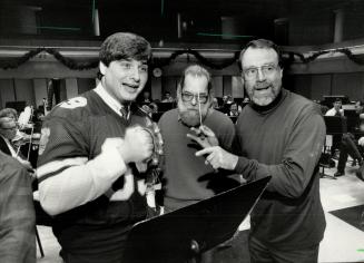 'Now, do I do it now, or what?' Dan Ferrone, captain of the Toronto Argonauts (left), has fun learning his cue for playing Jingle Bells at rehearsal i(...)