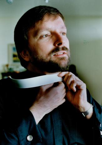 Time to go: Anglican priest James Ferry dresses today in preparation for Bishop's Court which later revoked his licence