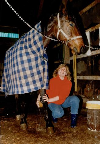Trainer Jeff Ginn helps helps Fish strap up her helmet, at top