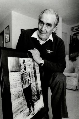 Former fighter pilot: Wally Floody, 69, the chief planner of the Great Escape from Stalag Luft III in 1944, holds a photo taken of himself during his internment