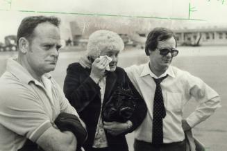 Terry's parents, Rolly and Betty Fox, and his constant companion, Bill Vigars stare almost in disbelief as Terry's stretcher is loaded onto aircraft