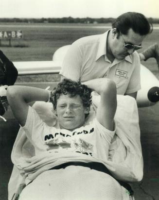 It's over: Terry Fox, tears streaming from his eyes, is loaded onto jet for the trip home