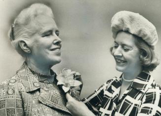 Anne Francis (Mrs. John Bird) who headed the Royal Commission on the Status of Women, has an orchid pinned on by Mrs. Elsa Jenkins, head of the CNE, w(...)
