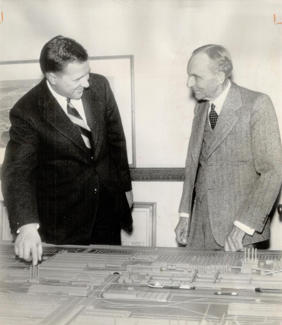 New Boss, Henry Ford II, left, who succeeds his grand father, Henry Ford, as president of the motor concern, looks over a scale model of the giant Ford Rouge plant