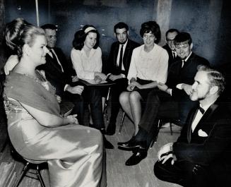 At the feet of talent. York University choir director William McCauley talks with contralto Maureen Forrester while a group of students admire from a (...)