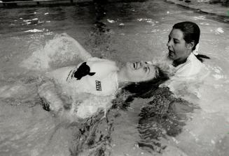 Going swimmingly: Volunteer Robin Crouch, right, helps Angela Feser, one of 24 disabled kids at Bloorview Children's Hospital's Terry Fox Swim yesterday