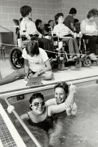 Charity swim: Patricia Thome, 18, helps Lynn Michaud, 17 (left), celebrate after Michaud was part of a team that swam 934 laps at Bloorview Hospital