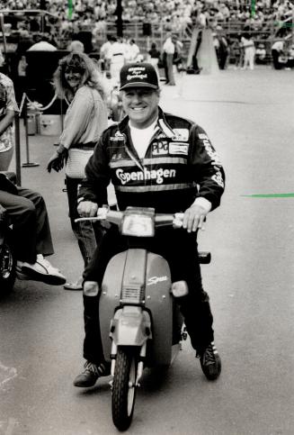 This is fun: A.L. Foyt draws a smile from a woman spectator as he drives around on a scooter yesterday