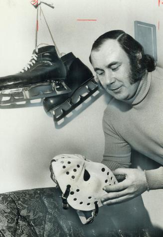 His career as a goaltender cut short by a heart attack at 33, Bruce Gamble holds the face mask he no longer needs