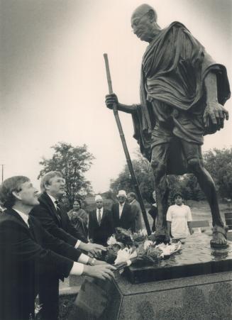 Honoring a man of peace. Ontario Citizenship Minister Gerry Phillips, left, and federal Finance Minister Michael Wilson lay flowers on a statue of Moh(...)