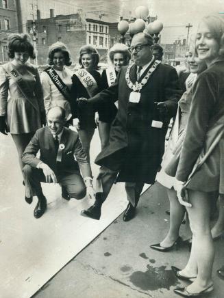 Kicks off Grey Cup. Mayor Philip Givens boots football to officially open the Grey Cup Festival. Ball holder in J. G. Sinclair, festival Chairman. The(...)
