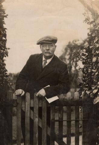 Arthur Conan Doyle leaning against fence