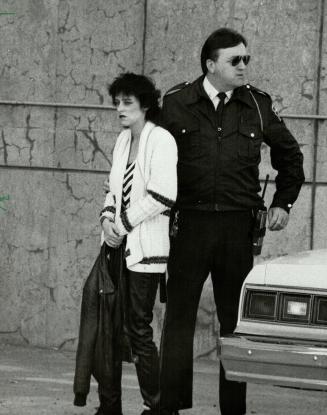 Suspected bank robber: Cindy May Raycroft, 19, is taken handcuffed into Whit by Jail today after being remanded on two charges of armed robbery and two charges of attempted murder