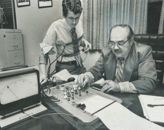 Star reporter George Gamester watches machine with which polygraph expert John Jurens is giving him a lie detector test