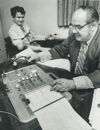 George Gamestar watches machine with which poly graph expert John Jurens is giving him a lie detector test the tube harness around gamester's chest measures his breathing