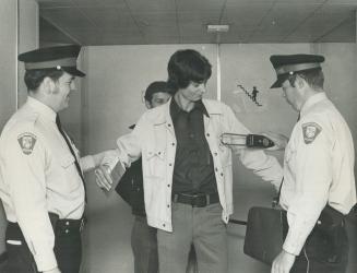 With an Electronic metal detector, Constable Ken Pollitt of Mississauga police checks Mike Marino of Exford Dr., Scarborough, at Toronto International Airport