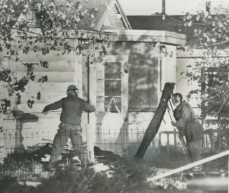 Checking for Booby Traps, two members of the Montreal bomb disposal squad cautiously examine objects in the house believed to have been used by the ca(...)