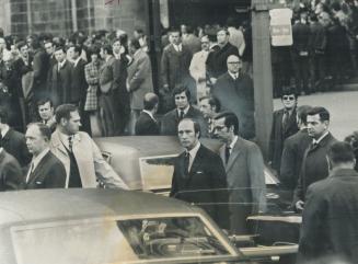 Prime minister Pierre Trudeau and Quebec Premier Robert Bourassa, surrounded by plainclothes security men, leave Notre Dame Church in Montreal after f(...)