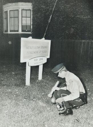 Policeman searches ground for spent cartridges