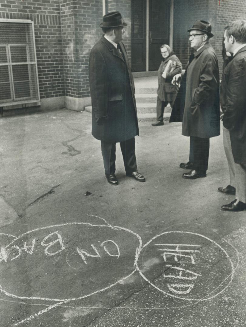 Detectives' chalk marks on the ground show where Dr. Jack Lindzon, 27, fell severely wounded after being shot by a gunman following a bank robbery tod(...)