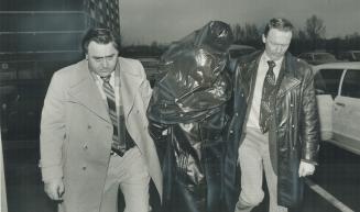 Faces maksed by garbage bags, three suspects in the pistol-whipping, $148,716 robbery of Canada Trust in Scarborough arrive at 41 division police station to take part in a line-up