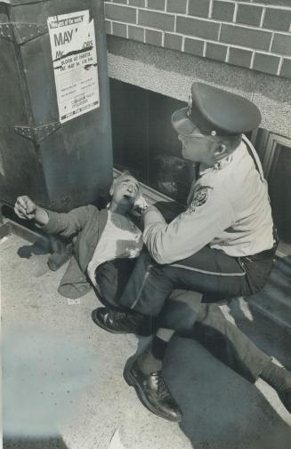 Pummelled to the Ground by a young robber who stole his watch while an accomplice looked on, Arthur Collings is helped by Police Cadet Richard Lackey.(...)