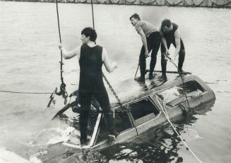 What a catch: Police Constables Angus Armstrong, left, Bill white and Bob Watt hooked a station wagon during a fishing expedition in Toronto Harbor yesterday