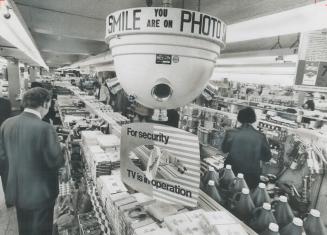Revolving television camera scans crowds at Canadian Tire store at Yonge St