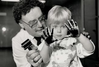 Sticky fingers, Two-year-old Katie Cashen got her hands all inky with the help of Metro Police Sergeant Don Taylor, but it's okay with her mom