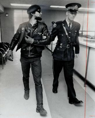 Nabbed by police during raid on a two-day convention of cyclists at the Satan's Choice motorcycle clubhouse, Peter Lorden, of Hamilton, Ont., puckers (...)