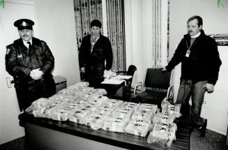 Recovered: Metro police officers stand guard over $3 million stolen yesterday from the Bank of Canada on University Ave
