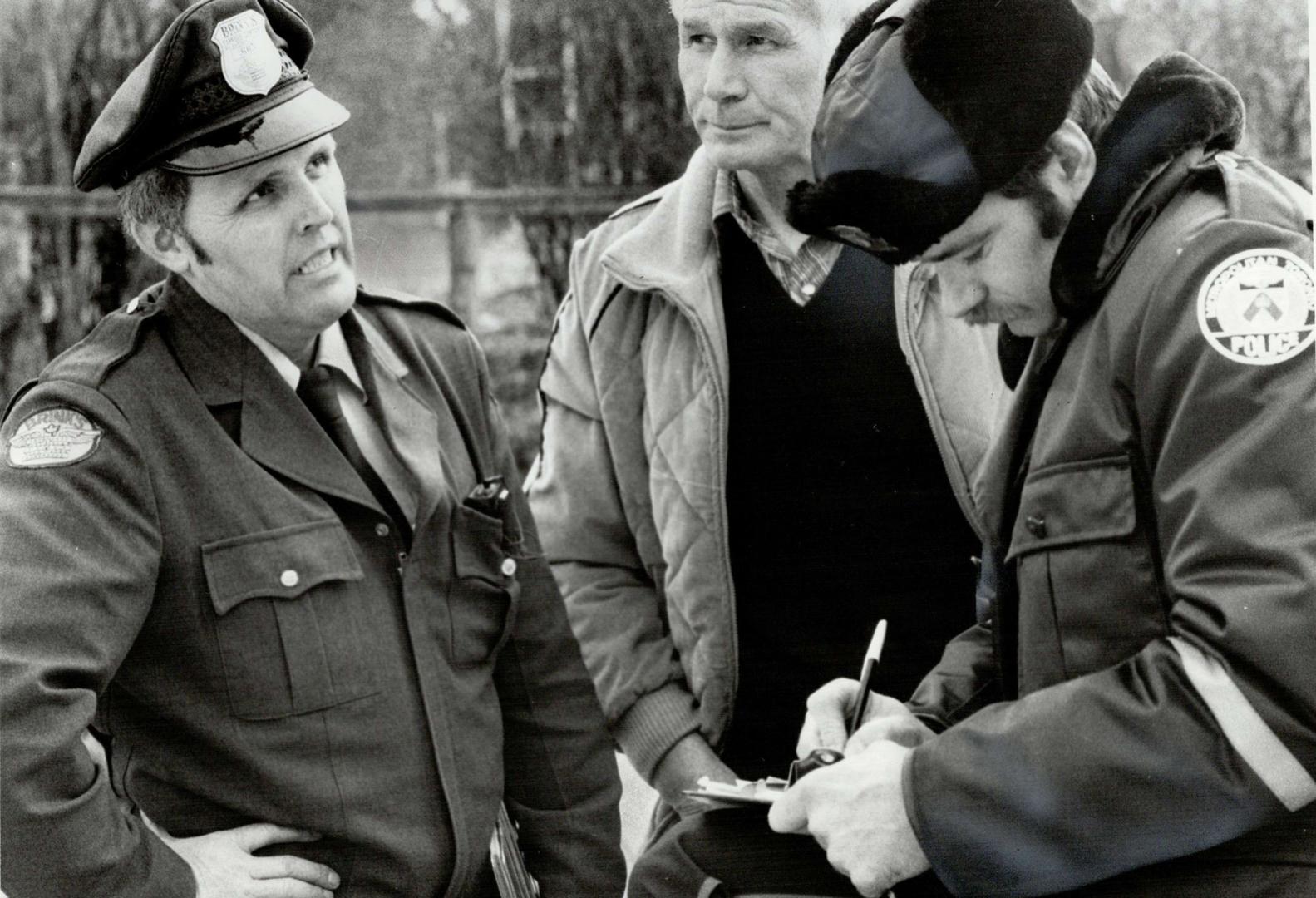 Victim and hero: Metro Police officer Mike Jenkins talks to an unidentified Brink's driver slugged by youthful holdup man
