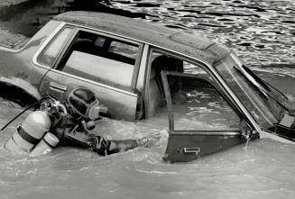 Car dumped in Humber: A Metro police diver checks a car discovered in the Humber River yesterday but finds no one trapped inside