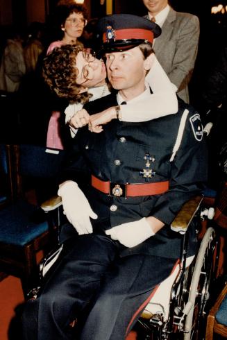 A kiss for a hero: Nepean Police constable Robin Easey, blind and paralyzed after being shot in 1984 while stopping a robbery, gets a kiss from his wife, Glennis, at Queen's Park yesterday