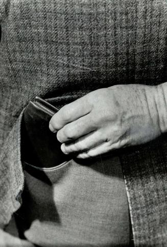 Nimble-fingered pickpocket gently lifting a wallet from pocket