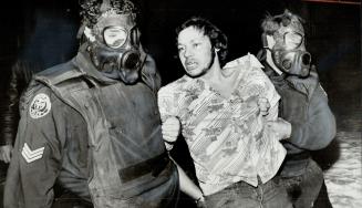 After An Eight-Hour Siege in which more than 30 rifle shots were fired from a Scarborough apartment, 26-year-old resident is taken from the tear-gas-filled premises by Metro Police Sgt