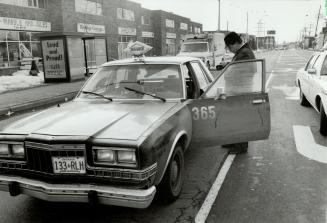 Bloody cab: Metro police check the cab in which they found its stabbed driver Ahmad Gondal yesterday on Weston Rd