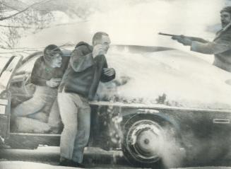 Hostage Warren Mitchell leaves his car yesterday as a policeman trains his rifle on parolee Francis Joseph Savoy, killed seconds later by a bullet in (...)