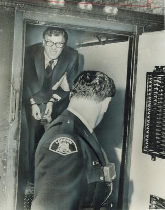 In handcuffs, Peter Demeter is led into London courthouse during his trial