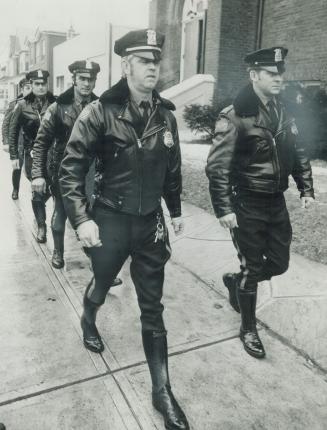 Detroit policemen, armed with 45-calibre revolvers, arrive at the church for the funeral of Metro detective Douglas Sinclair. Hundreds of police attended
