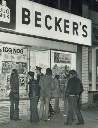 After Hold-up, and shooting that left manager of a Becker's milk store dead, bystanders gather outside to watch police investigate the death of Bill A(...)