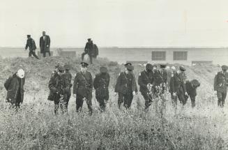Policemen search for clues in the field where Constable David Goldswrothy was found beaten and slot to death early this morning. Goldsworthy was patro(...)