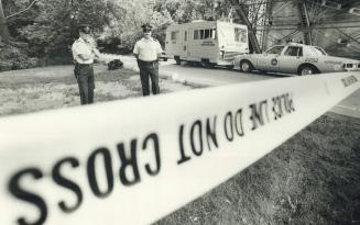 Murder site: Metro police officers stand guard behind a cordon sealing off the area where the body of 11-year-old Alison Parrott was found on Sunday