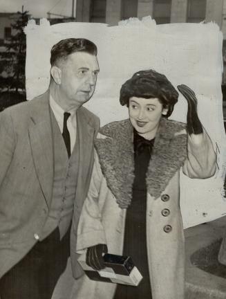 Cheery wave is given by Mrs. Dick as she leaves Barton St. jail for the courtroom today. Cooler weather kept the number of curious spectators down. A separate trial was order for Mrs. Evelyn Dick