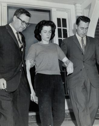 Wife of teacher, Mrs. Mary Garbella of Dalton St. is taken into custody by Det.-Sgt. Douglas Lewis (left) and Det.-Sgt. Ross of Fordham. She and husba(...)